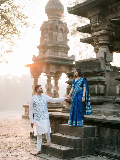 Leading the way to their future. This shot from Ankush and Aishwarya's pre-wedding session uses the morning light and ancient architecture to create a frame that feels both grand and personal.