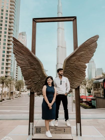 A formal pose in front of the Wings of Mexico sculpture, perfect for a classic save-the-date announcement.