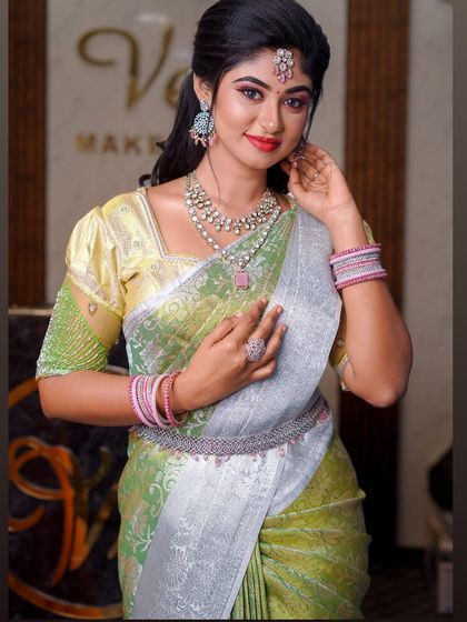 A light green and silver saree that creates a very fresh and modern look. The draping is soft and elegant, suitable for a daytime event or reception.