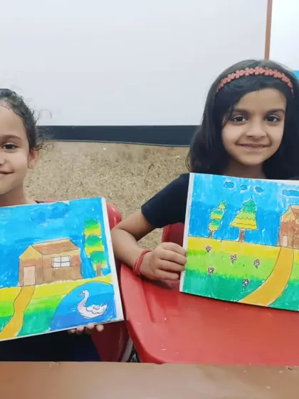 Two friends show off their matching landscape drawings. It's inspiring to see how students can work on the same theme yet add their own unique touches to their artwork.