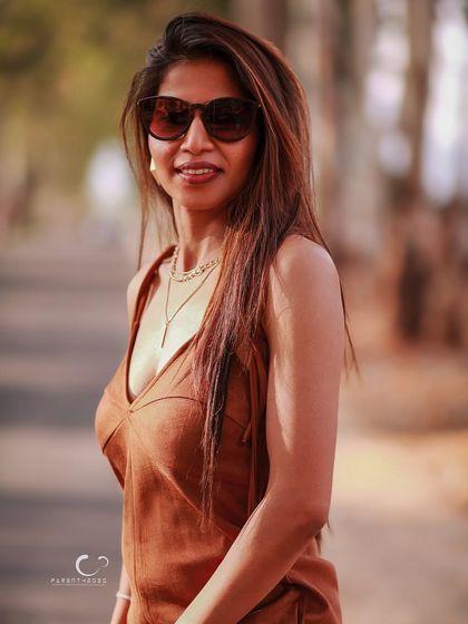 A cool and confident look with sunglasses. The blurred background and warm light create a classic, cinematic feel, perfect for a lifestyle portrait.