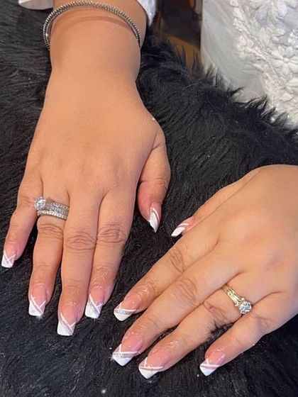 Double the lines, double the style. This French manicure features an extra silver glitter line alongside the white tip for a unique, layered look.