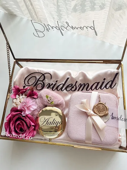 Asking your best friends to be your bridesmaids is a huge moment. I designed this personalized glass keepsake box with a satin robe, a custom mirror, and a jewelry organizer to make the proposal unforgettable.