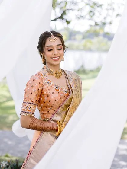 A moment of quiet happiness. The bride's eyes are closed, and her smile is serene, her makeup looking soft and flawless.