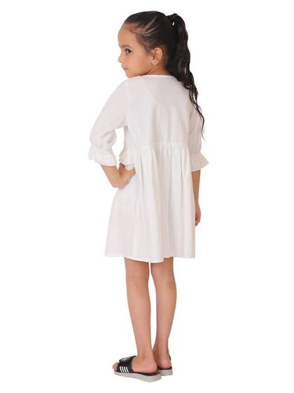 The back view of the white frock, essential for showing details like buttons or ties.