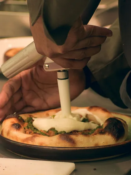 The final application of the potato parmesan espuma. This is a signature touch that makes my flatbread unique.