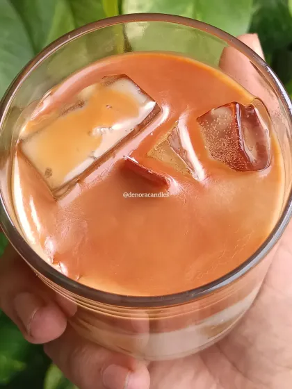 I created this hyper-realistic iced coffee candle for all the coffee lovers out there. It's made with layered soy wax to mimic the look of milk and coffee, complete with wax ice cubes, and fills the room with a rich coffee aroma.
