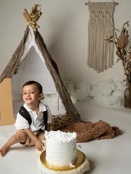 A stylish boho-themed cake smash for a little explorer turning one. This setup features a teepee, macrame details, and earthy tones for a minimalist yet whimsical first birthday photoshoot. It’s all about celebrating this big milestone with fun, laughter, and a little bit of mess.