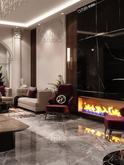 One of our favorite living rooms, featuring a cozy fireplace set in a black marble wall, plush seating in neutral and deep red tones, and neoclassical details like columns and wall mouldings.