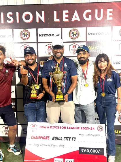 The leadership team celebrating with the championship trophy. Our success is a collective effort from everyone involved in the club.