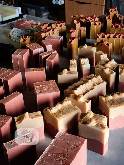 A studio shot filled with freshly cut soaps in shades of pink and brown. Each bar is a piece of unadulterated luxury, ready to be packaged and sent to you.