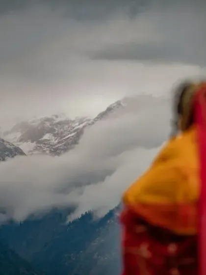 A creative shot of the bride looking towards the snow-capped peaks, her form blurred to draw attention to the magnificent mountain view.