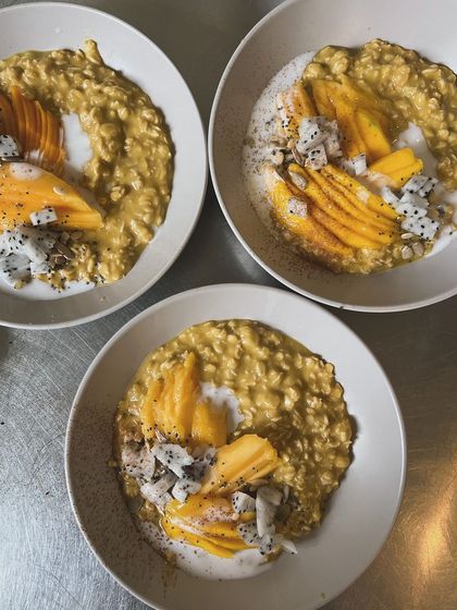 During mango season, our Mango Overnight Oats become an instant bestseller. Here are three bowls ready to go out, topped with fresh mango, dragonfruit, and a drizzle of coconut milk.