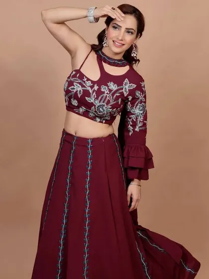 I love creating fusion wear, and this maroon Indo-Western lehenga set is a personal favorite. The crop top features intricate floral embroidery, paired with a flowing skirt, making it a stunning choice for a wedding guest or festive party.