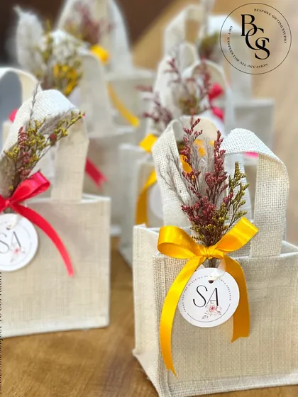 Simple, eco-friendly, and beautiful. These small jute bags, personalized with an initial tag and a colourful ribbon, are a wonderful option for sustainable return gifts, perfect for a rustic or bohemian-themed event.