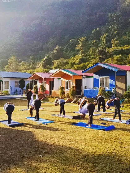 Students practicing a forward fold during our yoga retreat. The beautiful cottages and mountain scenery provide a perfect backdrop for our practice.