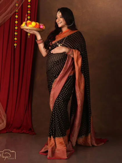 Holding a thali of flowers, this mama-to-be looks radiant and graceful in her traditional attire.