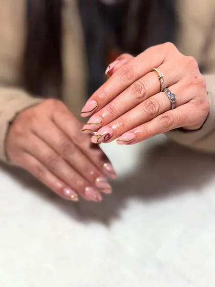 A minimalist design with a nude base and delicate gold abstract lines. This is a perfect example of 'less is more'.