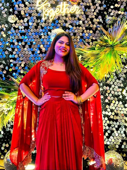 Dressed in red for a party with a very glittery backdrop. Love the disco ball effect.