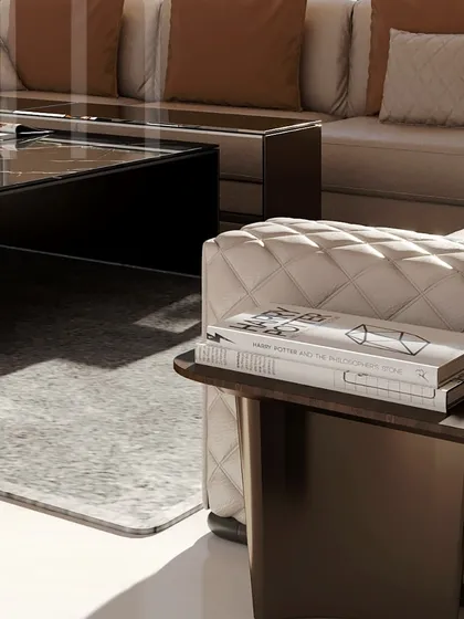 A close-up of the quilted sofa and bespoke side table. Every detail, from the stitching to the curated books, is chosen to create a sense of elegant and intentional living.