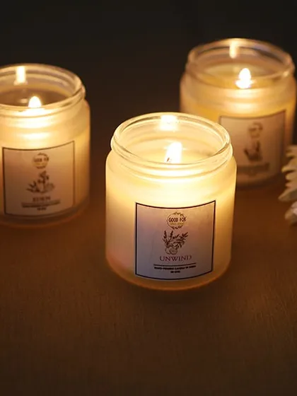 An atmospheric shot of scented candles, with the warm glow of the flames creating a serene and inviting mood for a home fragrance or gift brand.