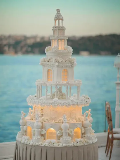 From grand decor to the smallest details, we ensure every element is perfect. This magnificent, multi-tiered wedding cake, illuminated from within, served as a stunning centerpiece for a seaside reception.
