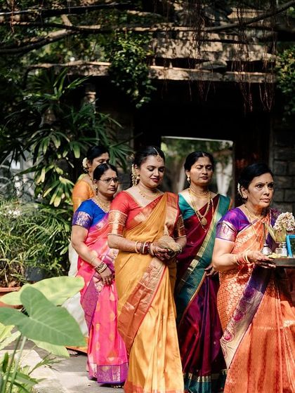 The bride's family, dressed in beautiful sarees, walks in a procession for the ceremony.