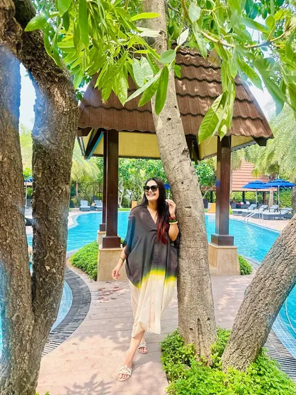 A still shot from the resort, where the stack of dark wooden bangles on my wrist adds a beautiful, earthy contrast to the poolside setting.