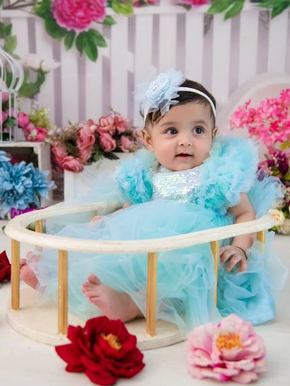 A beautiful portrait in a floral garden setting. The soft blue and pink tones create a dreamy and delicate atmosphere.