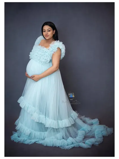 Another beautiful angle from the same session, this portrait captures a serene moment of reflection. The studio lighting perfectly highlights the textures of the ruffled gown and her happy, peaceful expression.