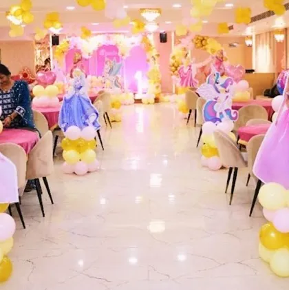A full view of a princess-themed party hall, with character cutouts of different Disney princesses lining the aisle, creating a royal welcome.