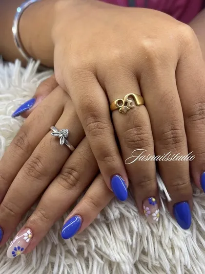 A beautiful royal blue manicure with delicate, hand-painted daisy accent nails. It's a simple way to add a touch of art to your look.