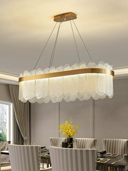 This elegant rectangular chandelier features scalloped glass pieces that create a soft, textured light. It's an ideal choice for hanging over a formal dining table.