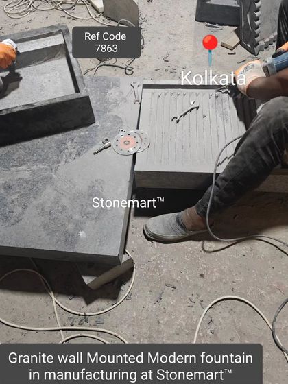 The components of a granite wall-mounted modern fountain are laid out during the manufacturing process.