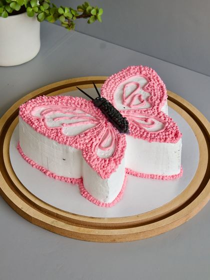 When a little girl has her heart set on a butterfly, you bring that vision to life. This butterfly-shaped cake is a great example of my "minimal cream, maximum flavor" style, focusing on a beautiful shape and delicate piping work.