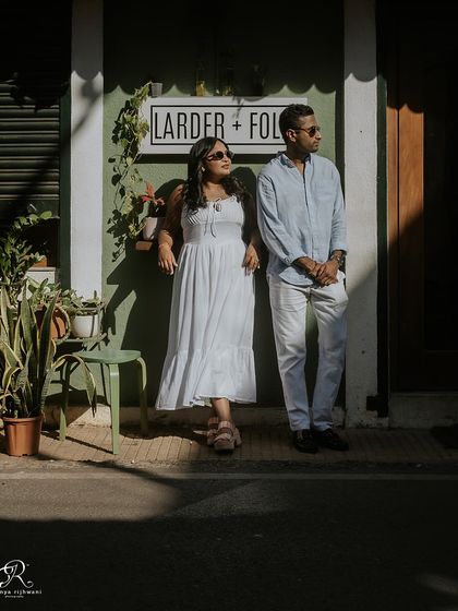 A cool, stylish pose against the charming storefront in Fontainhas. This shot has a relaxed, editorial feel, showcasing the couple's modern vibe during their Goa shoot.