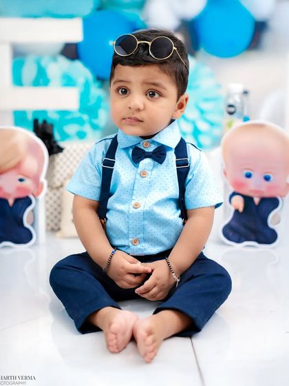 This little "Boss Baby" looks thoughtful, with his sunglasses perched on his head. Even the serious moments during a cake smash are adorable.