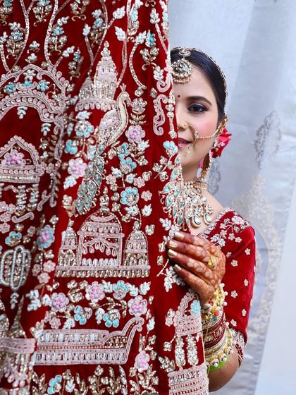 My beautiful bride Geeta peeking from behind her intricate red lehenga. A very creative and lovely shot.