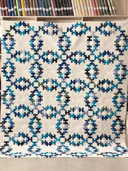 The Summer Wedding Ring is a timeless pattern, and our detailed ruler work and free-motion quilting in the open spaces give this version a stunning, elegant finish that highlights the intricate piecing.