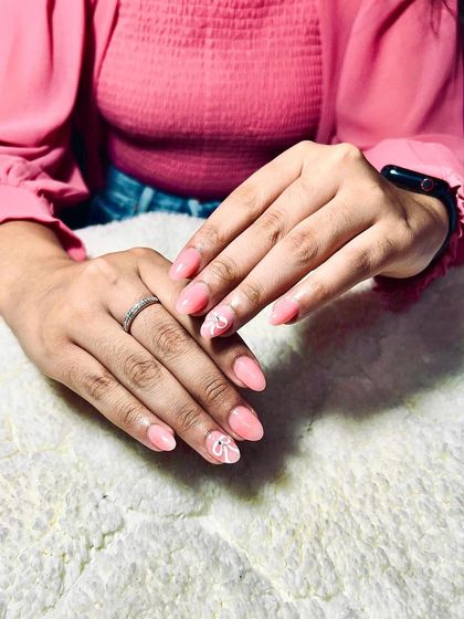 A soft and delicate look with a sheer pink base and subtle white leaf art on the accent nails.