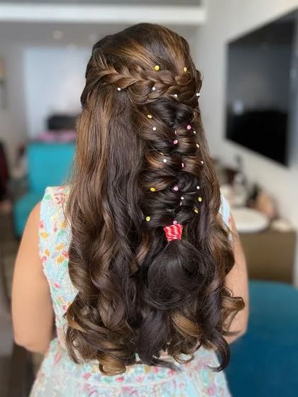 This twisted boho braid is perfect for a Haldi or Mehendi look. The colorful beads add a fun and festive touch to the half-up, half-down style.