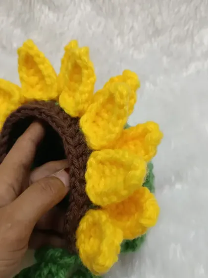 Showing the depth of the sunflower bonnet. It's designed to fit a newborn's head comfortably.