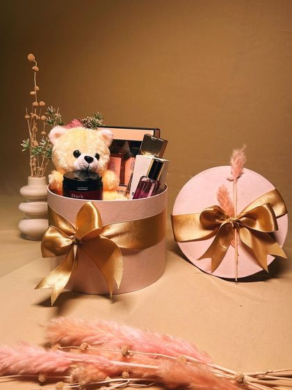 A beautifully styled shot of the 'Sweet Serenity' hamper packed in a round pink gift box with a large golden bow, ready to delight your special someone.