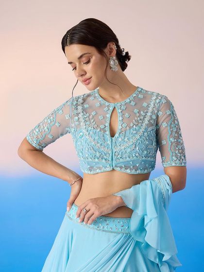 A close-up of the sheer blouse with delicate floral embroidery, a key feature of this beautiful blue lehenga.