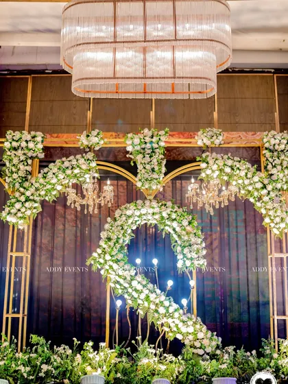A close-up of a custom floral monogram, the letter "S," serving as the centerpiece of a stage backdrop. This demonstrates our ability to create personalized and branded elements for any corporate or private event.