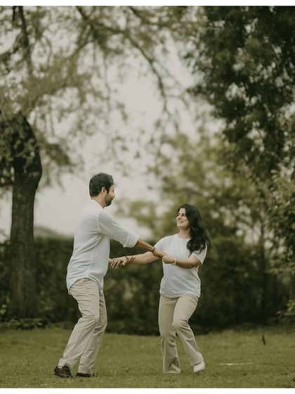 A candid shot of a couple dancing together in a park. Their joyful expressions and natural movements make this a heartwarming and authentic portrait.