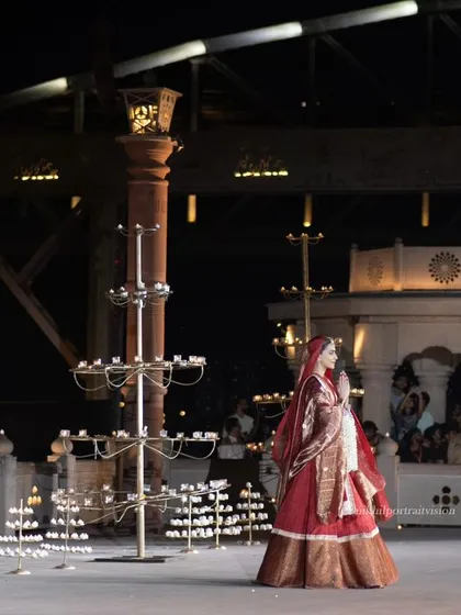 A side view of Kriti Sanon on the stage, which is adorned with traditional diyas. This image beautifully merges the worlds of fashion and culture.