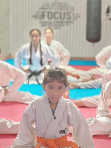 Focus is everything. A young karateka holds her stretching pose, building both physical and mental endurance.