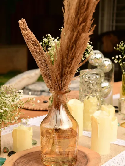 A detail shot of the table, showing how we mixed baby's breath, pampas grass, and small disco balls in vases to add a touch of unexpected sparkle to the rustic theme.