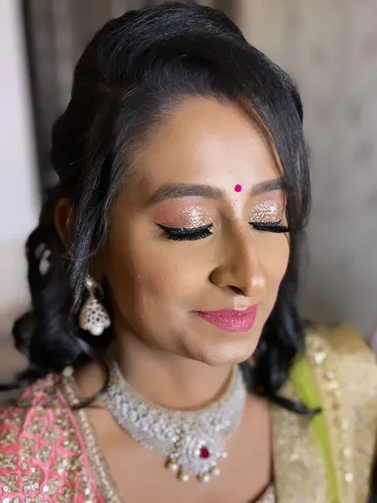 A detailed shot of the reception eye makeup. Champagne glitter on the lids with a sharp black wing liner creates a look that is both glamorous and elegant.